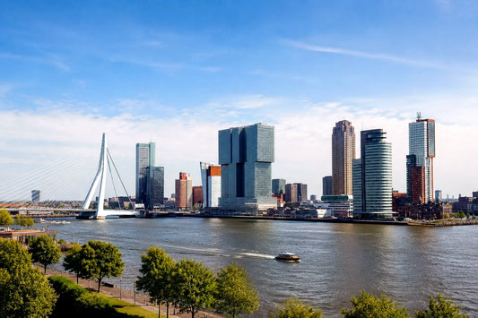 “8K breedbeeldfoto van de moderne skyline van Rotterdam met de iconische Erasmusbrug bij zonsondergang – stijlvolle landmarkfoto voor meubels herstofferen en meubelstoffering in Rotterdam.”